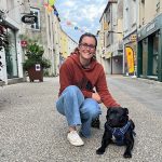 Clémentine et son chien posent dans une rue pietonne