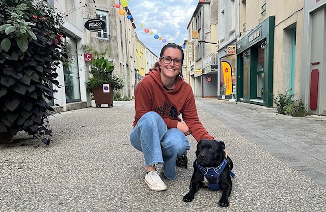 Clémentine et son chien posent dans une rue pietonne
